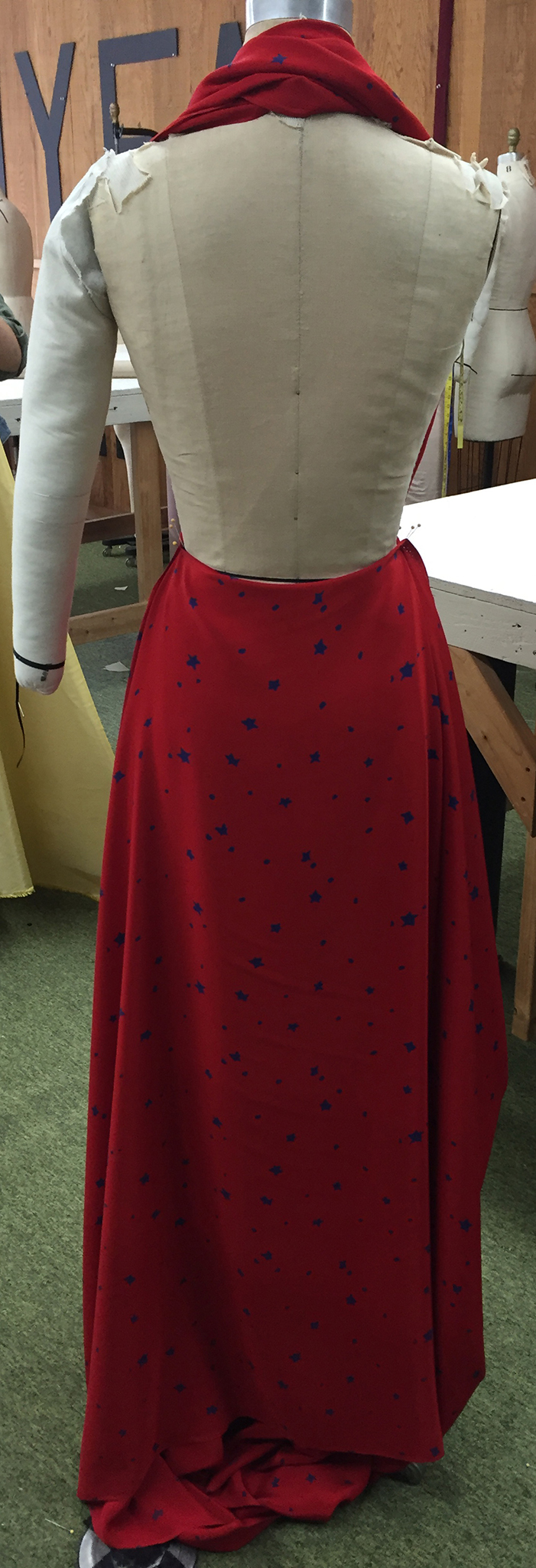 Red silk crepe with blue stars draped over a dress form.