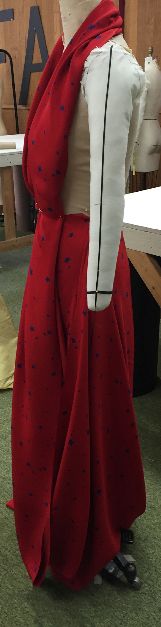 Red silk crepe with blue stars draped over a dress form.