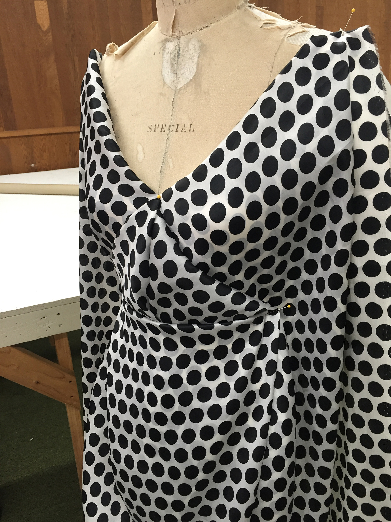 10 yards of continuous white silk organza fabric with black polka dots draped over a dress form.