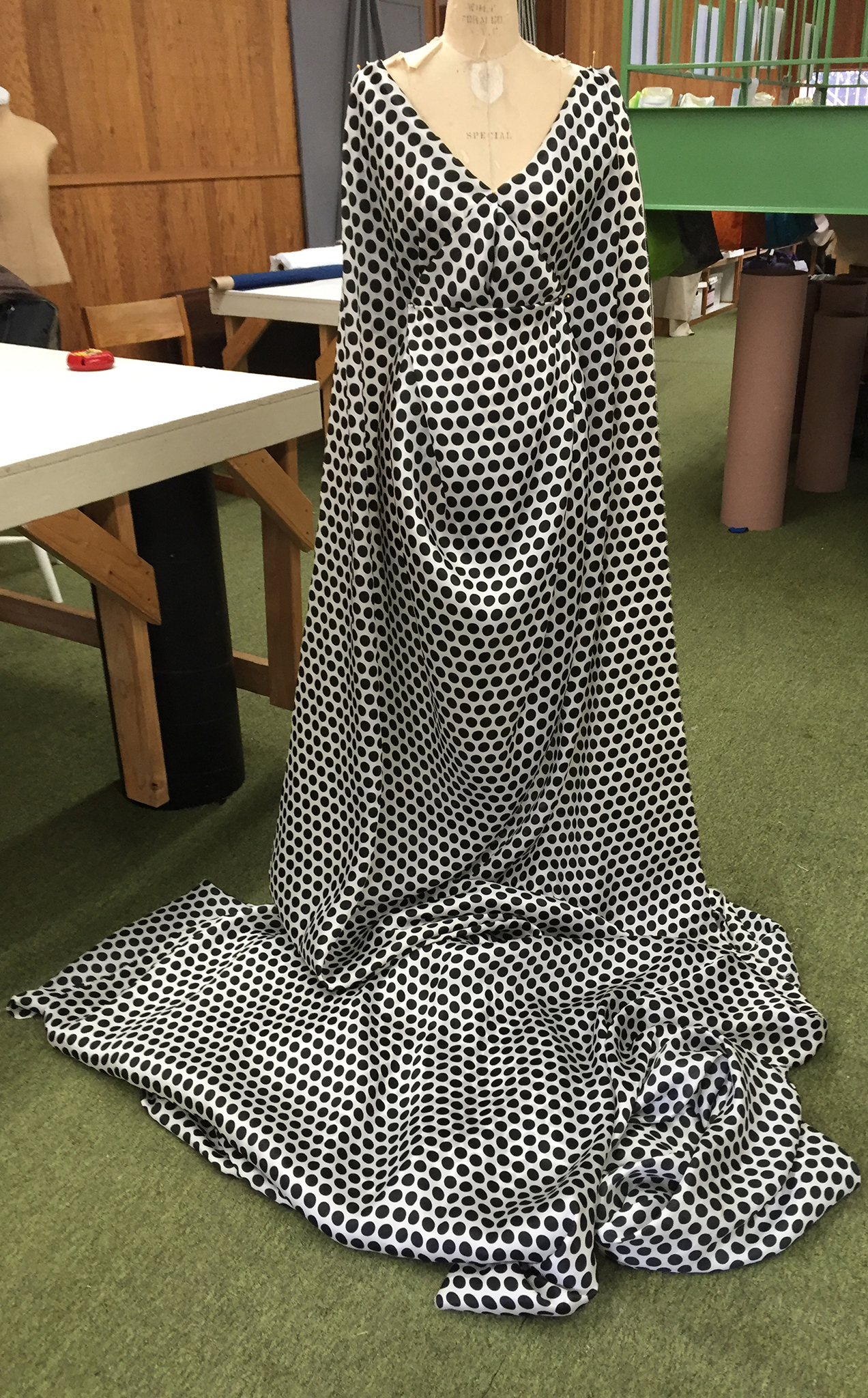 10 yards of continuous white silk organza fabric with black polka dots draped over a dress form.