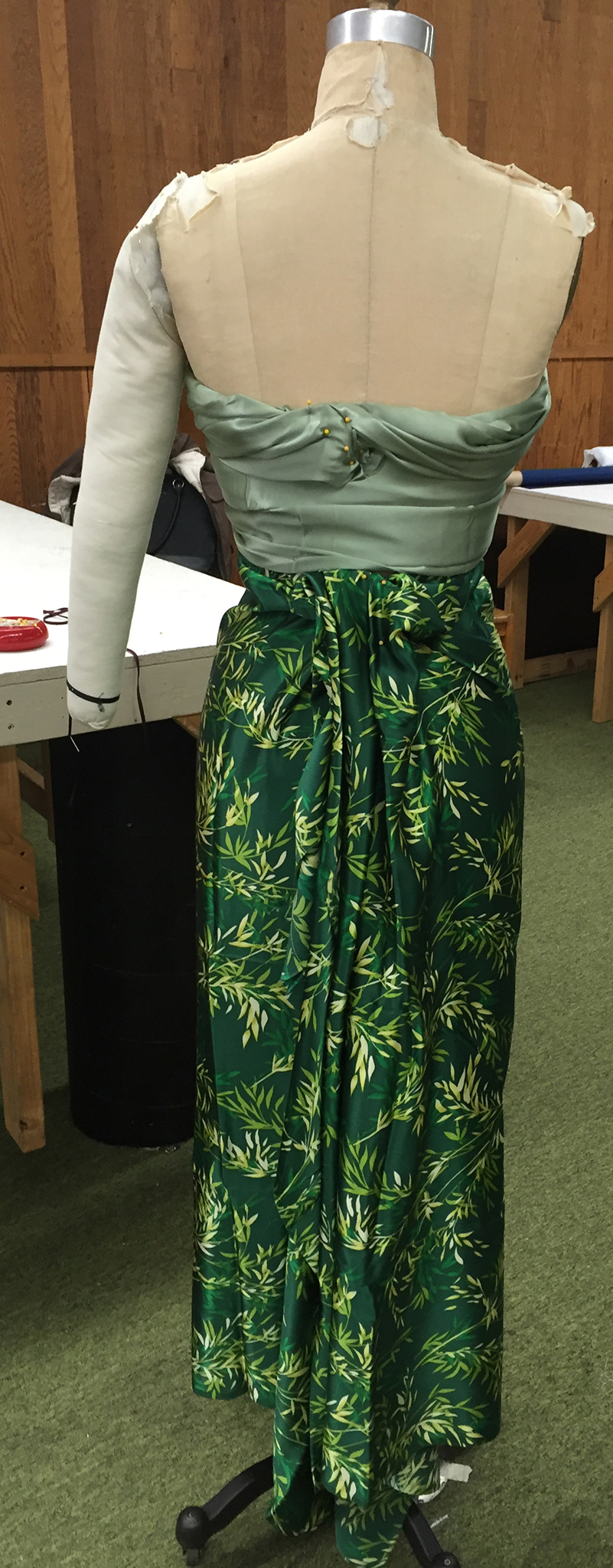 Two different bolts of green charmeuse fabric draped over a dress form.