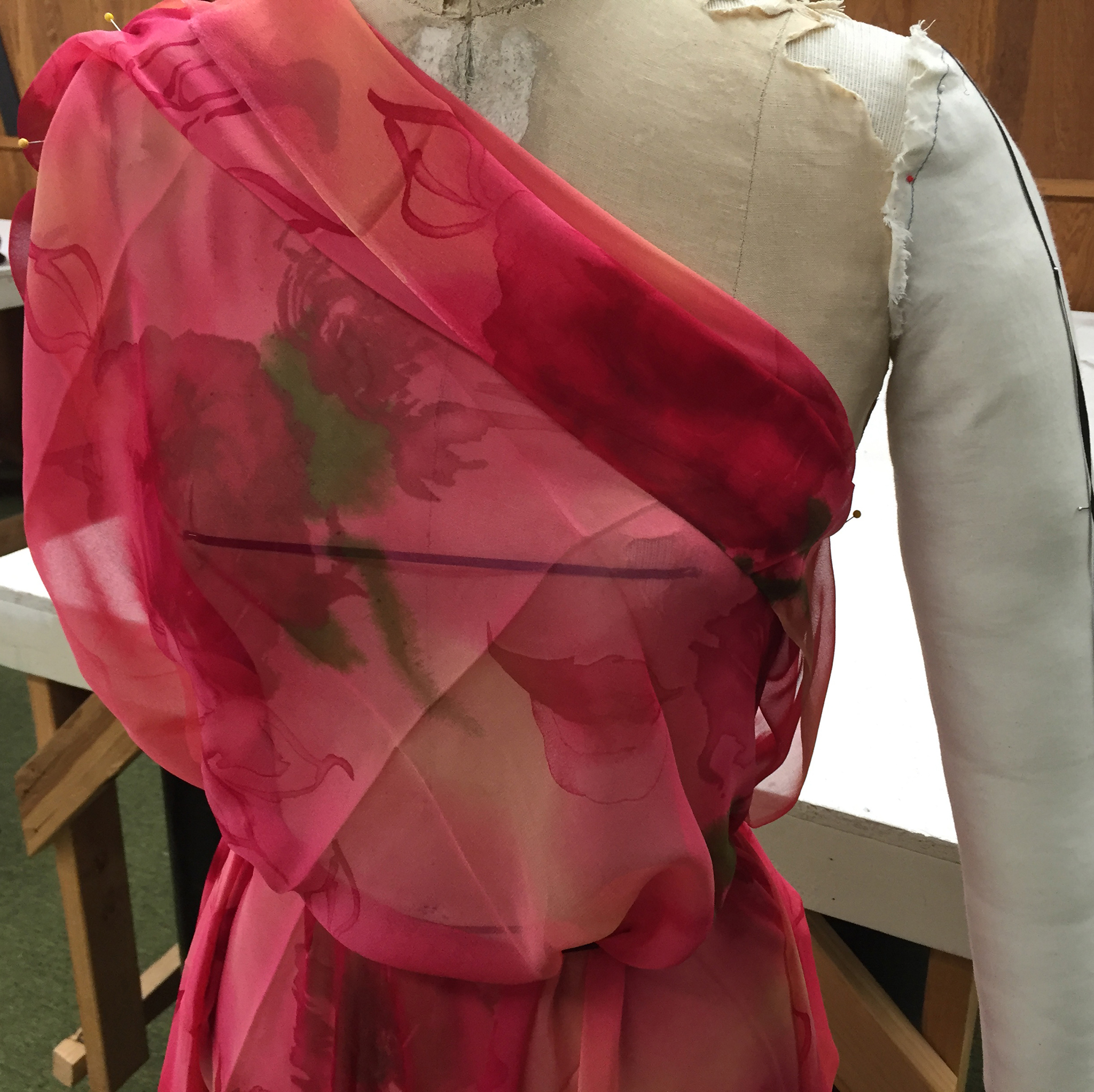 Pink floral silk chiffon draped over a dress form.