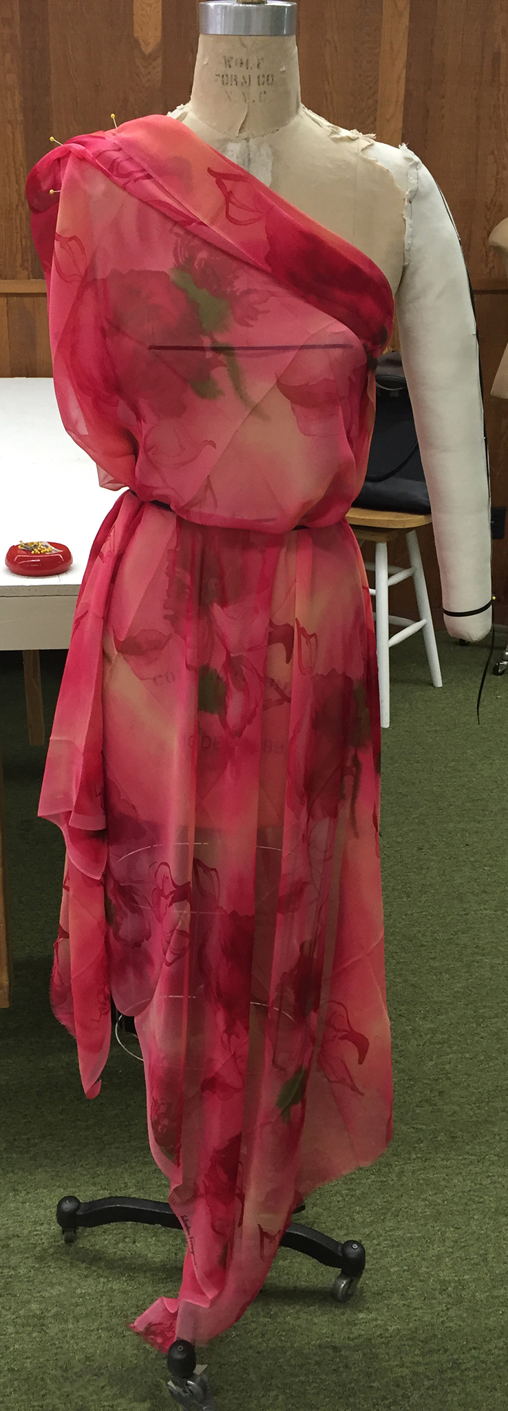 Pink floral silk chiffon draped over a dress form.