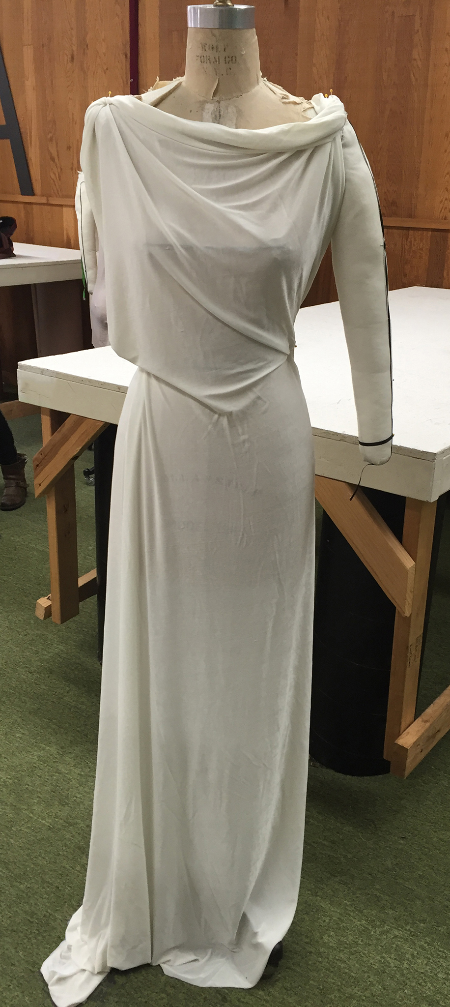 White knit fabric draped over a dress form.