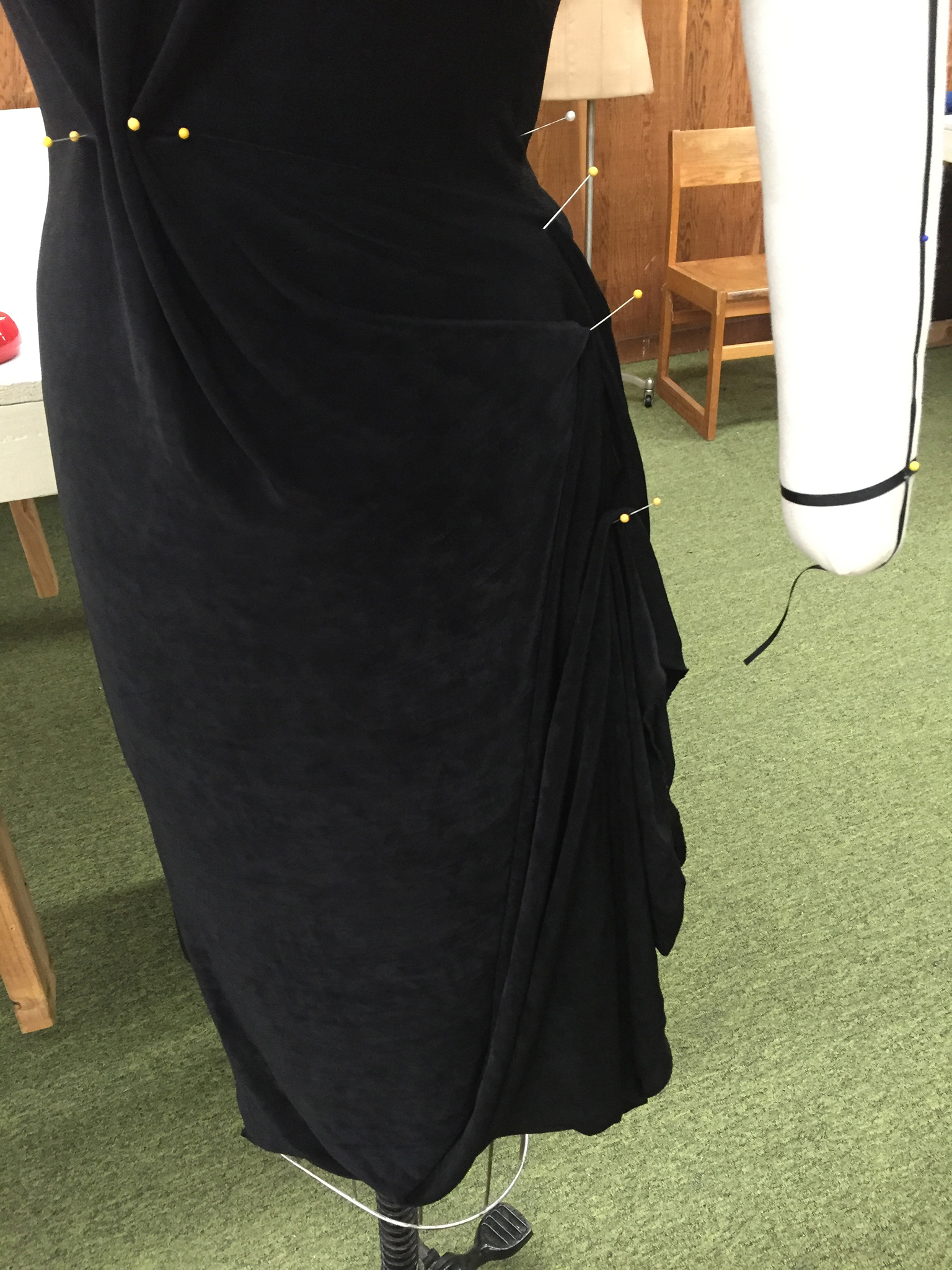 Black knit fabric draped over a dress form.